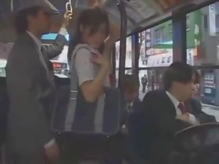 الآسيوية في سن المراهقة صديقة متلمس في حافلة بواسطة مجموعة